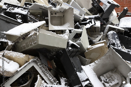 Snow-covered, garbage, old office equipment. Electronic waste devices consist of a monitor, a printer, a desktop computer and a fax for reuse. Plastic, copper, glass can be reused, recycled or recycle