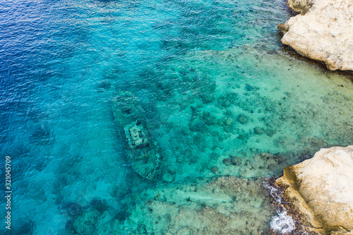 Aerial view of coast of Curaçao in the Caribbean Sea with turquoise water, cliff, beach and beautiful coral reef over Tugboat Beach