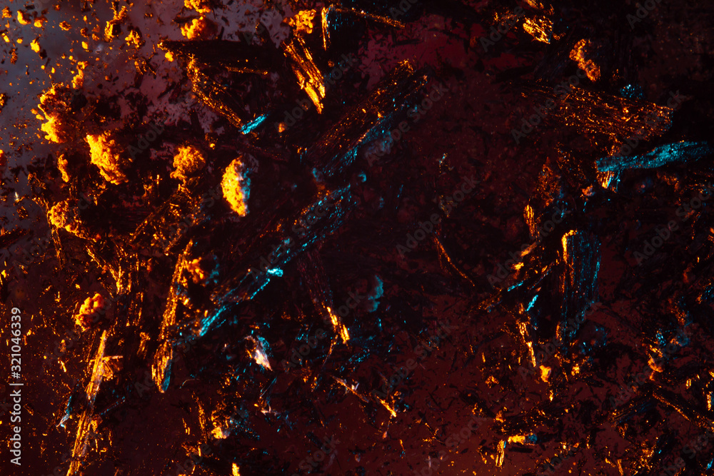 coals scatter in different directions with a blue-orange backlight on a dark background. close up copy space coals scatter in different directions with a blue-orange backlight on a dark background. close up copy space