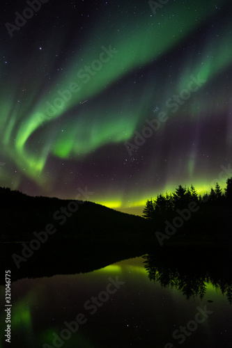 Northern lights in norway. Sea with reflection on aurora borealis