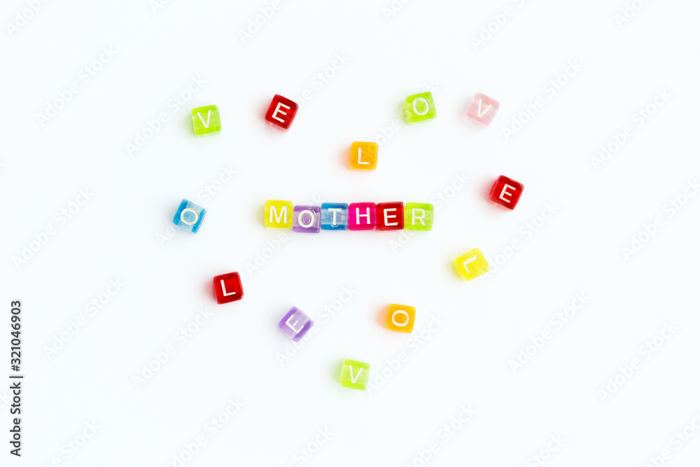 Top view on sign mother from small colorful letters and heart from colored letters with text love. Mother day card. Woman day. 8 march. Mothers day concept. White background. Top view on sign mother from small colorful letters and heart from colored letters with text love. Mother day card. Woman day. 8 march. Mothers day concept. White background.