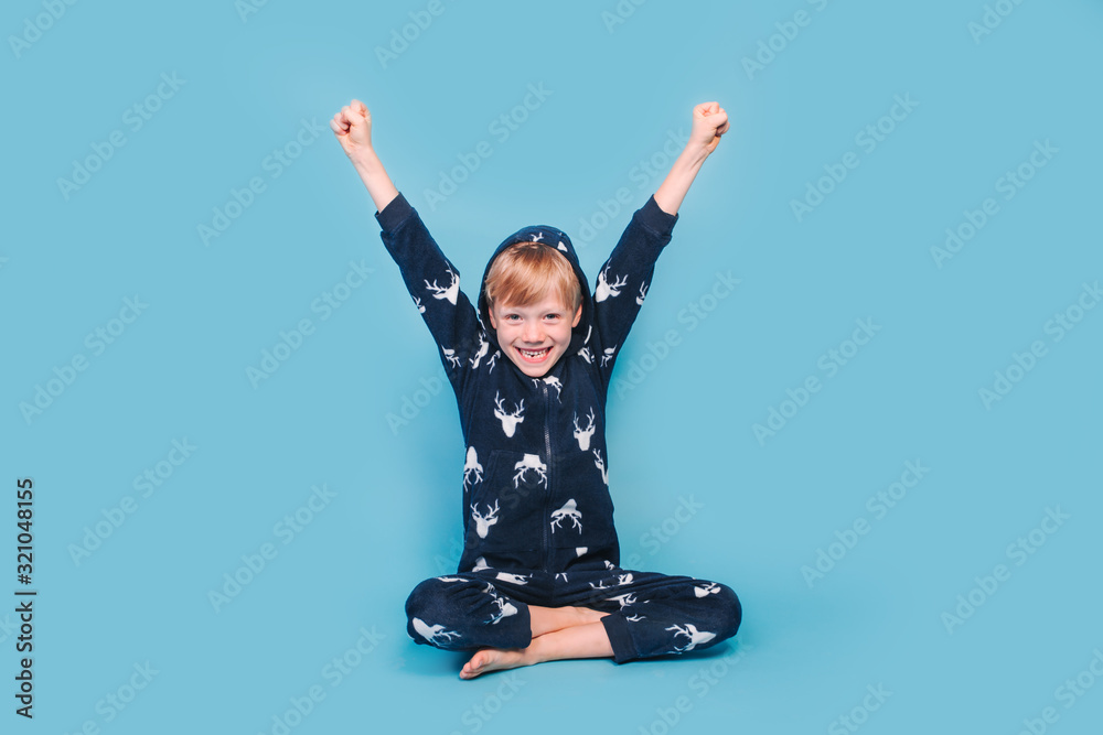 Happy little boy in warm pajamas waking up in the morning - obrazy, fototapety, plakaty 