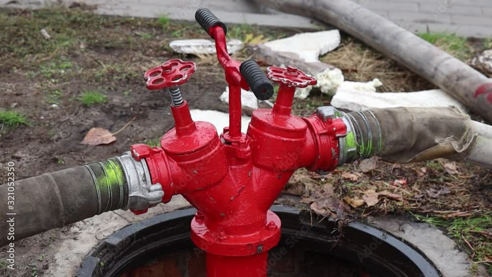 Fire hydrant on the side of the street lit by street lamps. Red fire hydrant in rainy weather. footage Fire hydrant on the side of the street lit by street lamps. Red fire hydrant in rainy weather. footage
