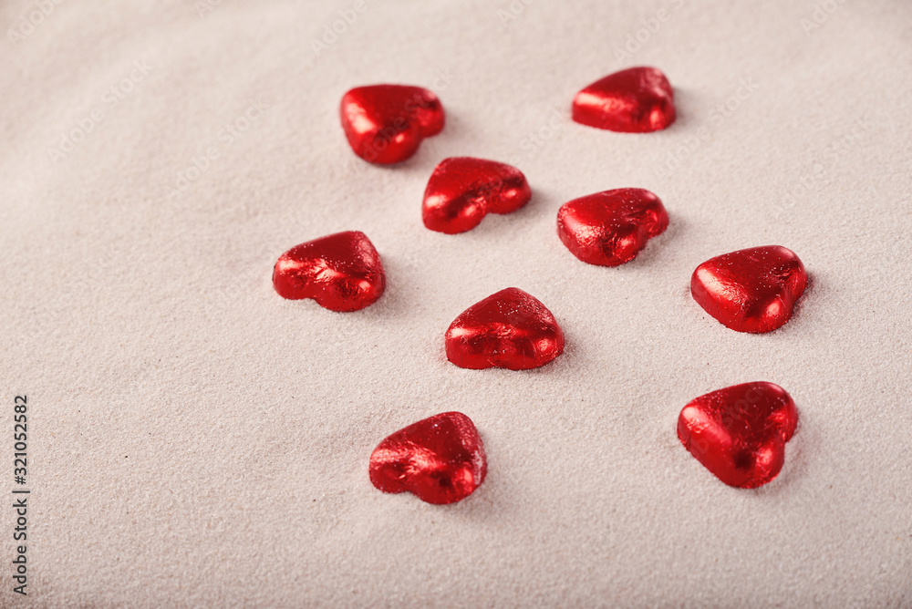 Chocolate red praline hearts on the beach sand on St. Valentine's Day Chocolate red praline hearts on the beach sand on St. Valentine's Day
