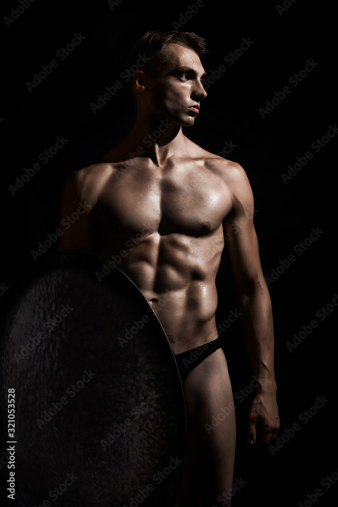 Young warrior with shield isolated on black. Young warrior with shield isolated on black.