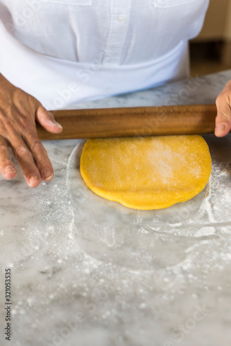 Italian woman rolling out homemade pasta dough photo