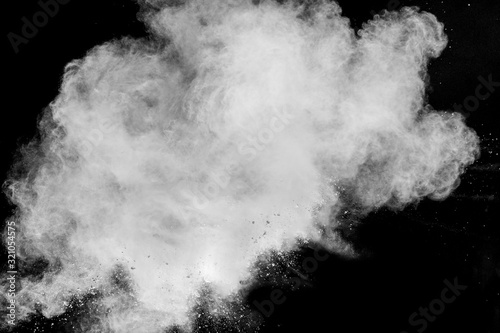 Wybuch proszku białego na białym na czarnym tle. Białe cząsteczki pyłu splash.