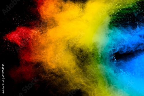 Freeze motion of colored powder explosions isolated on black background.Color dust particle splatter on background.