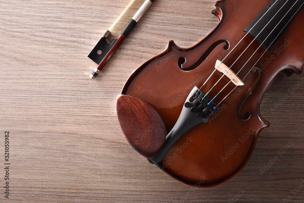 Fototapeta premium Violin body and bow with detail on wooden table top