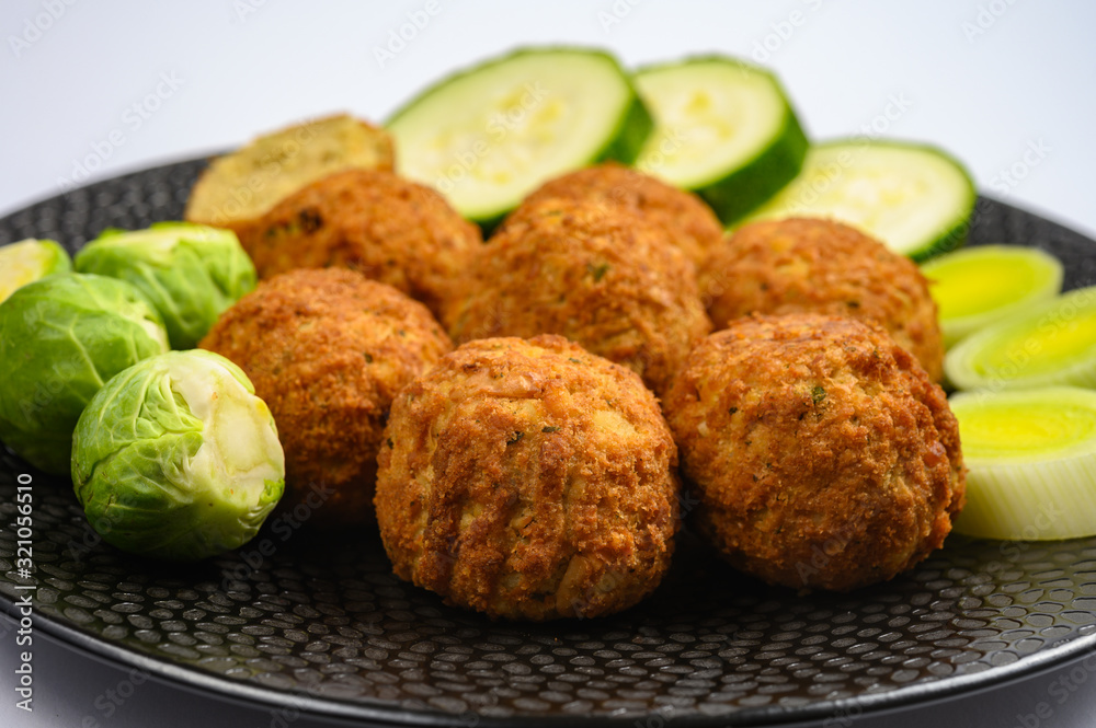 Cooking of healthy vegetarian food, tasty check pea falafels and frehs green vegetables Cooking of healthy vegetarian food, tasty check pea falafels and frehs green vegetables