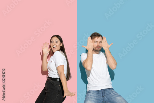 Romantic. Dancing, moving, having fun. Young and happy man and woman in casual clothes on pink, blue bicolored background. Concept of human emotions, facial expession, relations, ad. Beautiful couple.