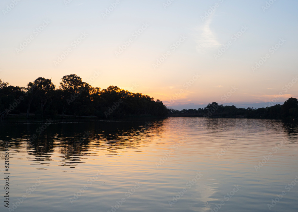 Obraz premium The Murray River at sunset twilight sky, is Australia's longest river which drains most of inland Victoria, New South Wales, and southern Queensland. 