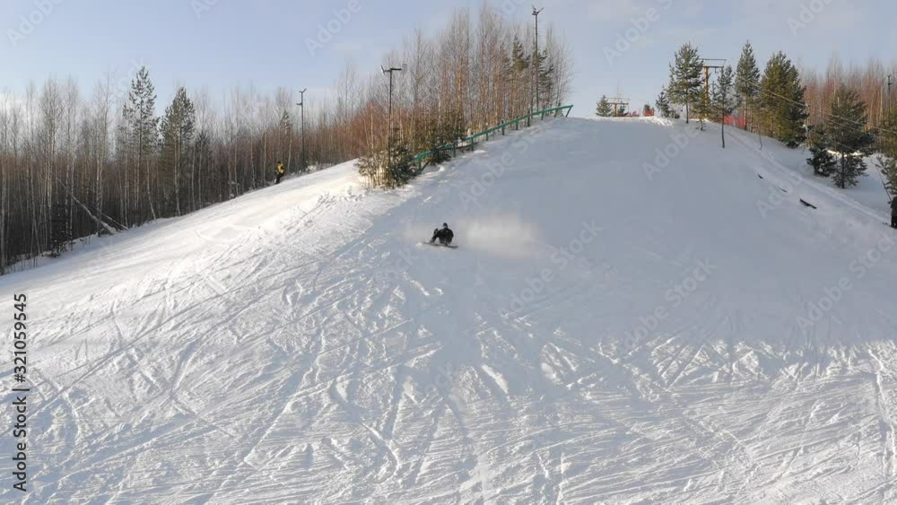 snowboarder falls on a mountainside on a winter day, top view snowboarder falls on a mountainside on a winter day, top view