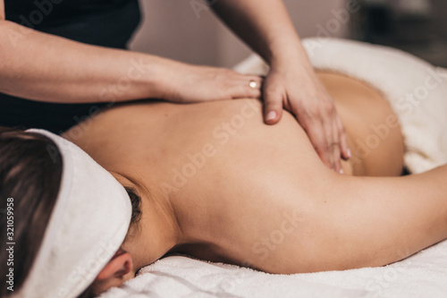 Post-traumatic rehabilitation with massage - a rehabilitation doctor performs a massage on the patient   s back