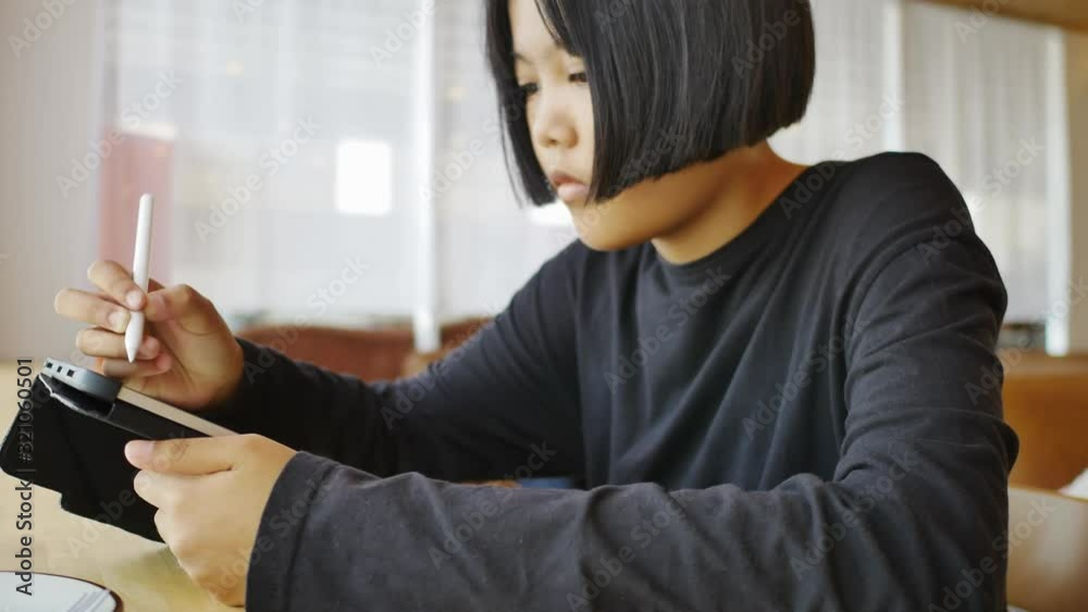 Asian teen doing homework by tablet, Education and technology concept Asian teen doing homework by tablet, Education and technology concept