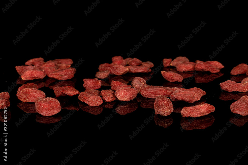 Lot of whole disordered dried red goji isolated on black glass Lot of whole disordered dried red goji isolated on black glass