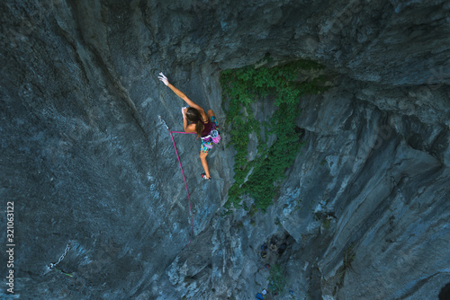 female sportive rock climber climbing
