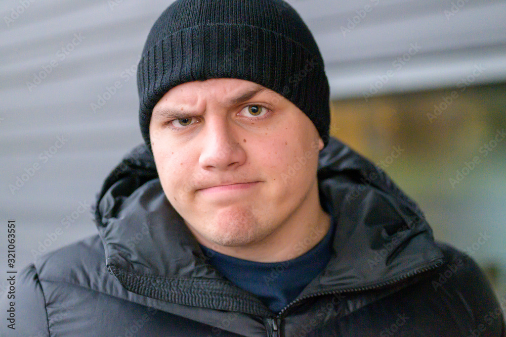 Determined sceptical young man frowning at camera Determined sceptical young man frowning at camera