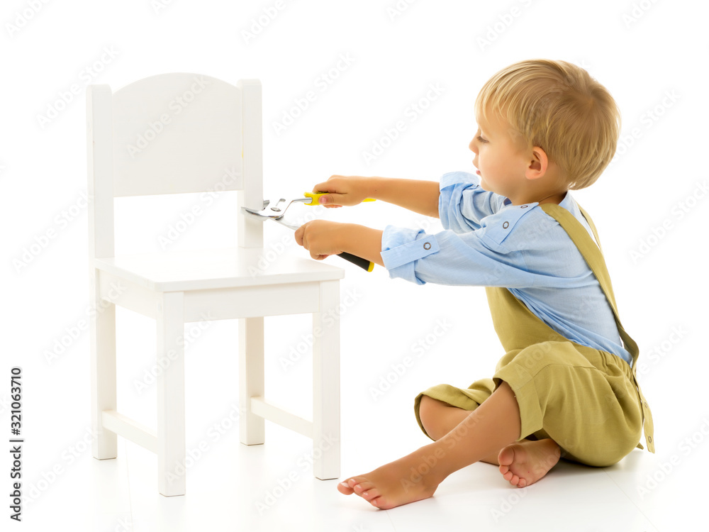 A little boy is repairing a chair. Montessori Kindergarten A little boy is repairing a chair. Montessori Kindergarten
