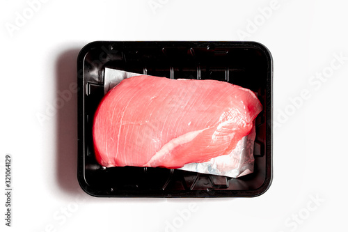 raw chicken breast meat in black plastic package isolated on white