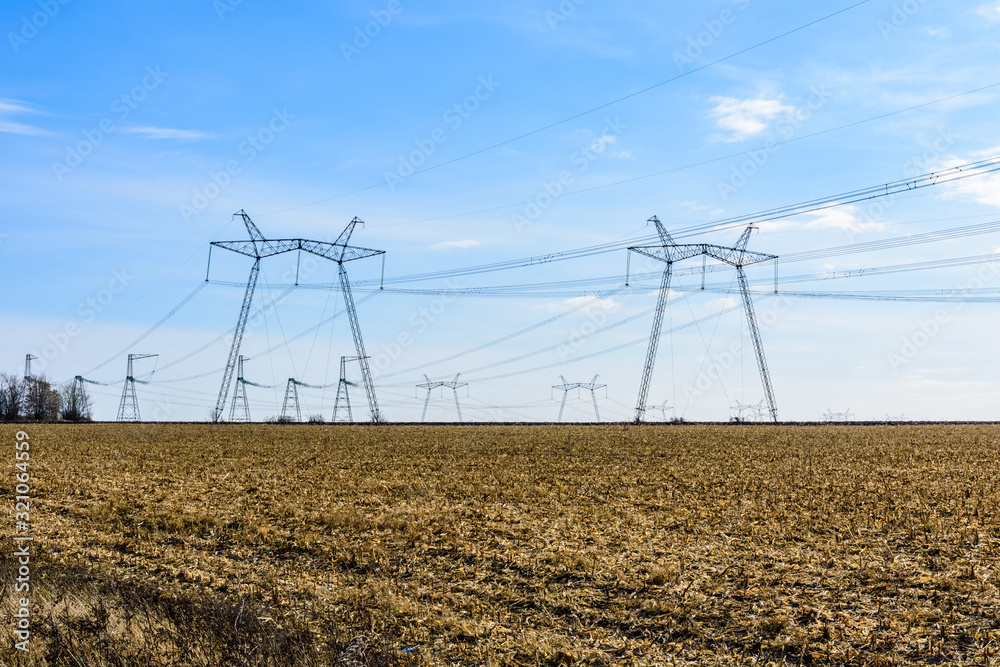 High voltage power line in a field on autumn