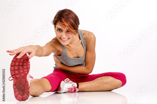 Plakat w ramie ragazza sportiva con i capelli a caschetto fa stretching dopo aver fatto attvità fisica - isolata su sfondo bianco