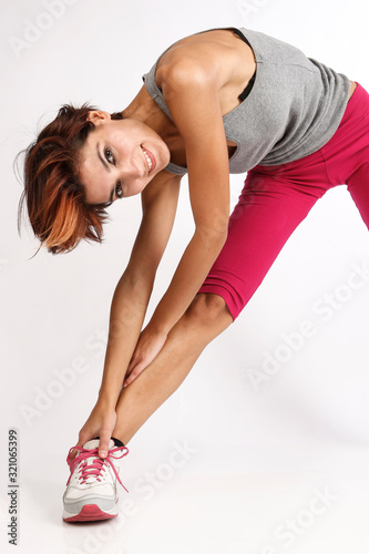 ragazza sportiva con i capelli a caschetto fa stretching dopo aver fatto attvità fisica - isolata su sfondo bianco