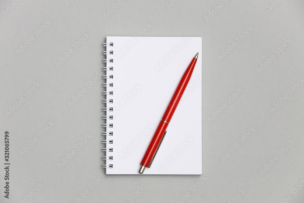 Blank notebook or notepad with red pen on gray desk background. Blank notebook or notepad with red pen on gray desk background.