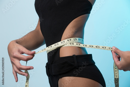 una ragazza molto in forma di prende le misure nella vita