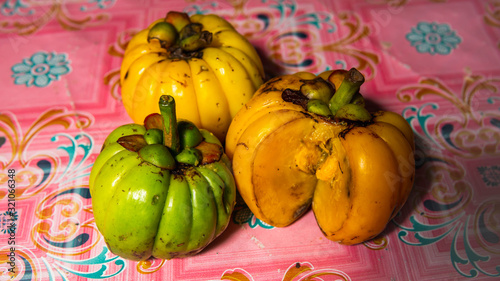 Garcinia atroviridis, known as asam gelugur or asam keping on a pink background. photo