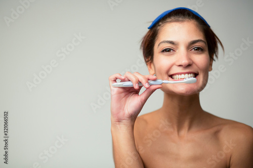 bella ragazza con i capelli corti    felice di lavarsi i denti  isolata su sfondo chiaro
