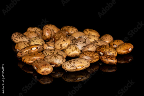 Lot of whole mottled brown bean pinto heap isolated on black glass
