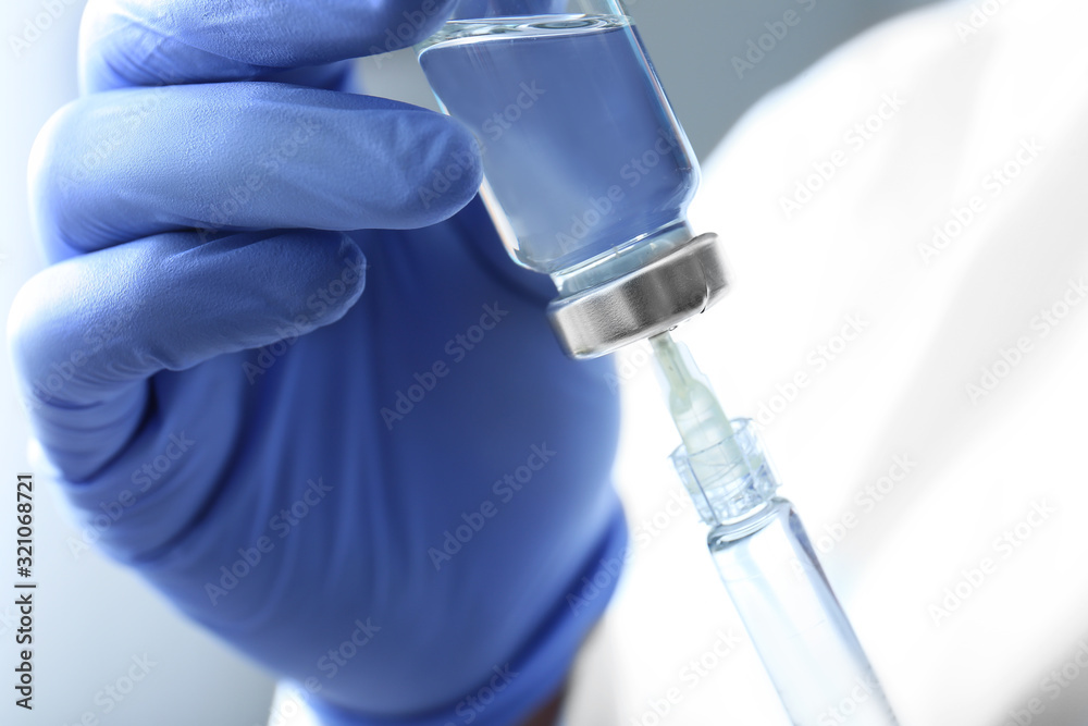 Cosmetologist with syringe and ampule with filler, closeup Cosmetologist with syringe and ampule with filler, closeup