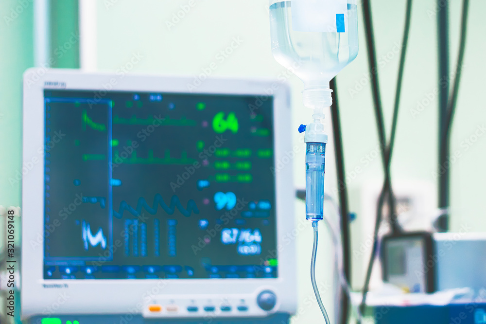 Dropper system against the background of the operating room. Monitor Monitors the patient's cardiogram during surgery. Dropper system against the background of the operating room. Monitor Monitors the patient's cardiogram during surgery.