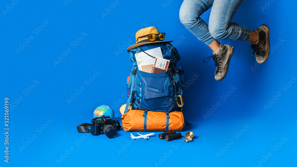 .Tourist planning vacation with the help of world map with other travel accessories around. Woman traveler with suitcase on Blue color background. Concept travel backpack .Tourist planning vacation with the help of world map with other travel accessories around. Woman traveler with suitcase on Blue color background. Concept travel backpack