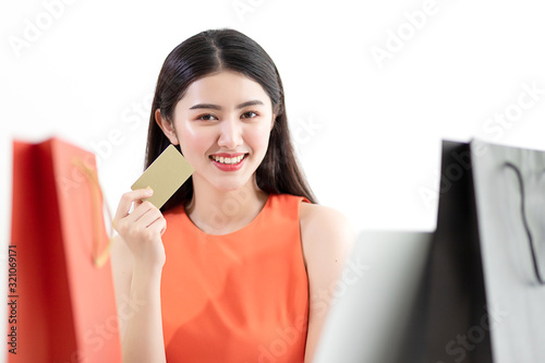 Picture showing smart attractive young asian girl holding credit card with happiness and joyful. Online shopping payment and e-commerce concept. photo