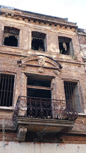 Facade of a very old brick house or building decayed and in ruin