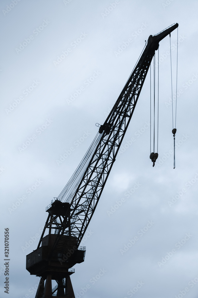 Port crane silhouette under cloudy sky Port crane silhouette under cloudy sky