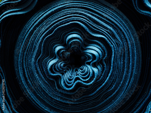 Roll of blue fabric close-up. The texture of the material in the fabric factory. Classic blue trend 2020. Bright blue background