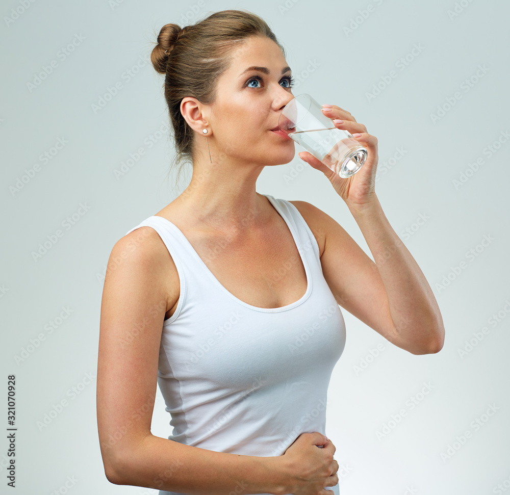 Sporty woman in white singlet drinking water. Sporty woman in white singlet drinking water.
