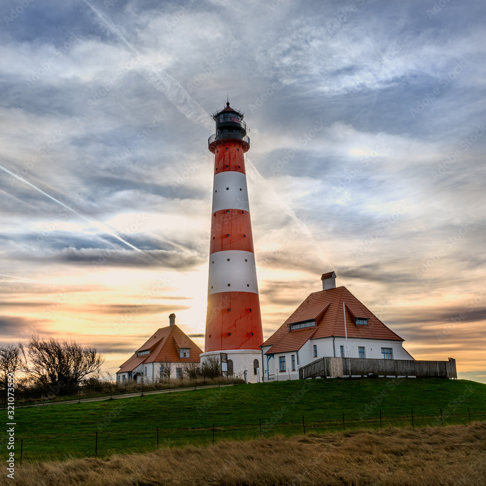 Lighthouse Westerhever at sunset with georgeous clouds and stunning colors at the North Sea in Schleswig Holstein, Germany