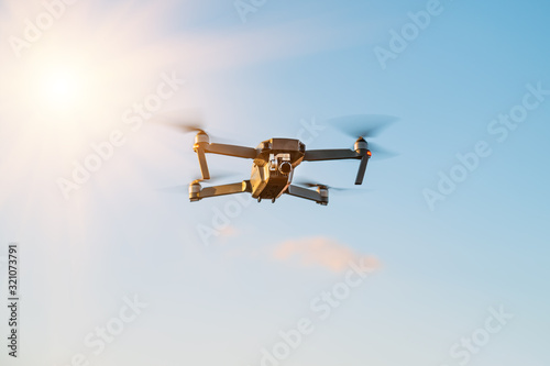 Remote controlled copter with digital camera on sky background. Closeup. New tool for aerial photo and video © fotolesnik