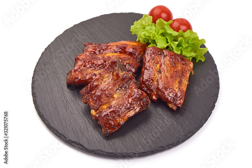 Delicious grilled pork ribs in BBQ on stone plate, isolated on white background