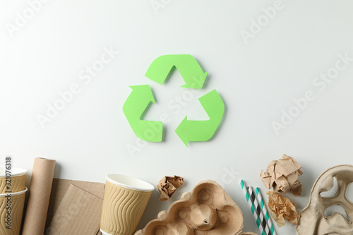 Recycle sign on white background with different trash, top view