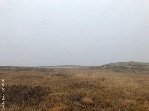 Landscape & travel photography in no man's land along the Golden Circle Route in iceland by Gullfoss Waterfall: clouds in the sky & barren, rural nordic land with black stones next to Hvita river