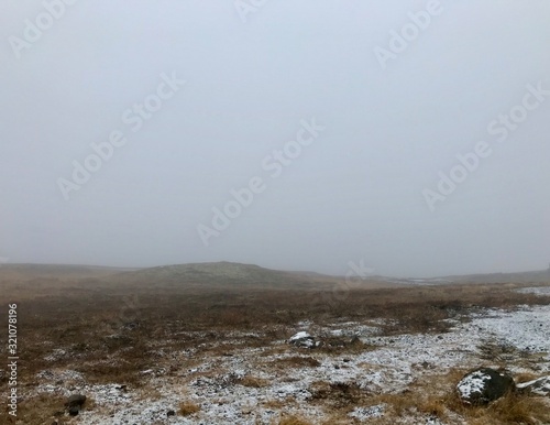 Landscape & travel photography in no man's land along the Golden Circle Route in iceland by Gullfoss Waterfall: clouds in the sky & barren, rural nordic land with black stones next to Hvita river