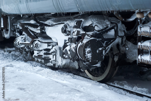 Slika na platnu ice covered bogie of a railway passenger carriage on rails in winter