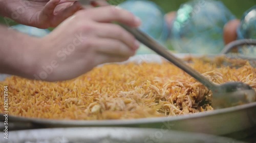 Person serving paella from a pan photo