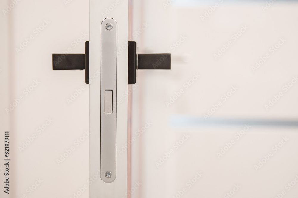 Metal doors knob handle with magnetic lock on modern interior Metal doors knob handle with magnetic lock on modern interior