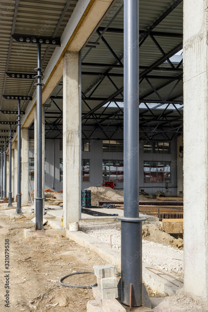 Construction site. Metal posts hold the aluminum roof. Construction of the hangar. Construction site. Metal posts hold the aluminum roof. Construction of the hangar.